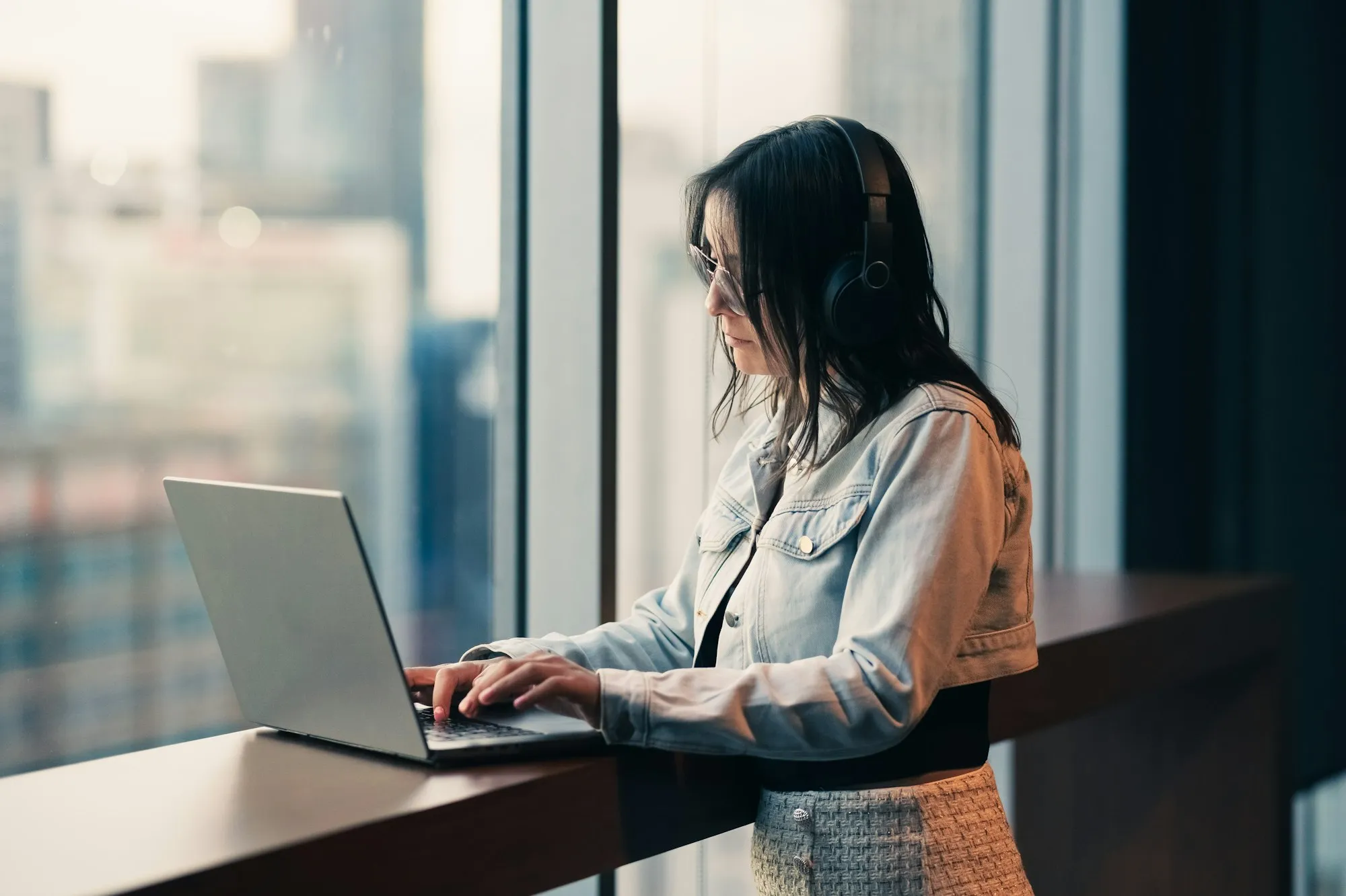 Someone working at a desk with a laptop and notes