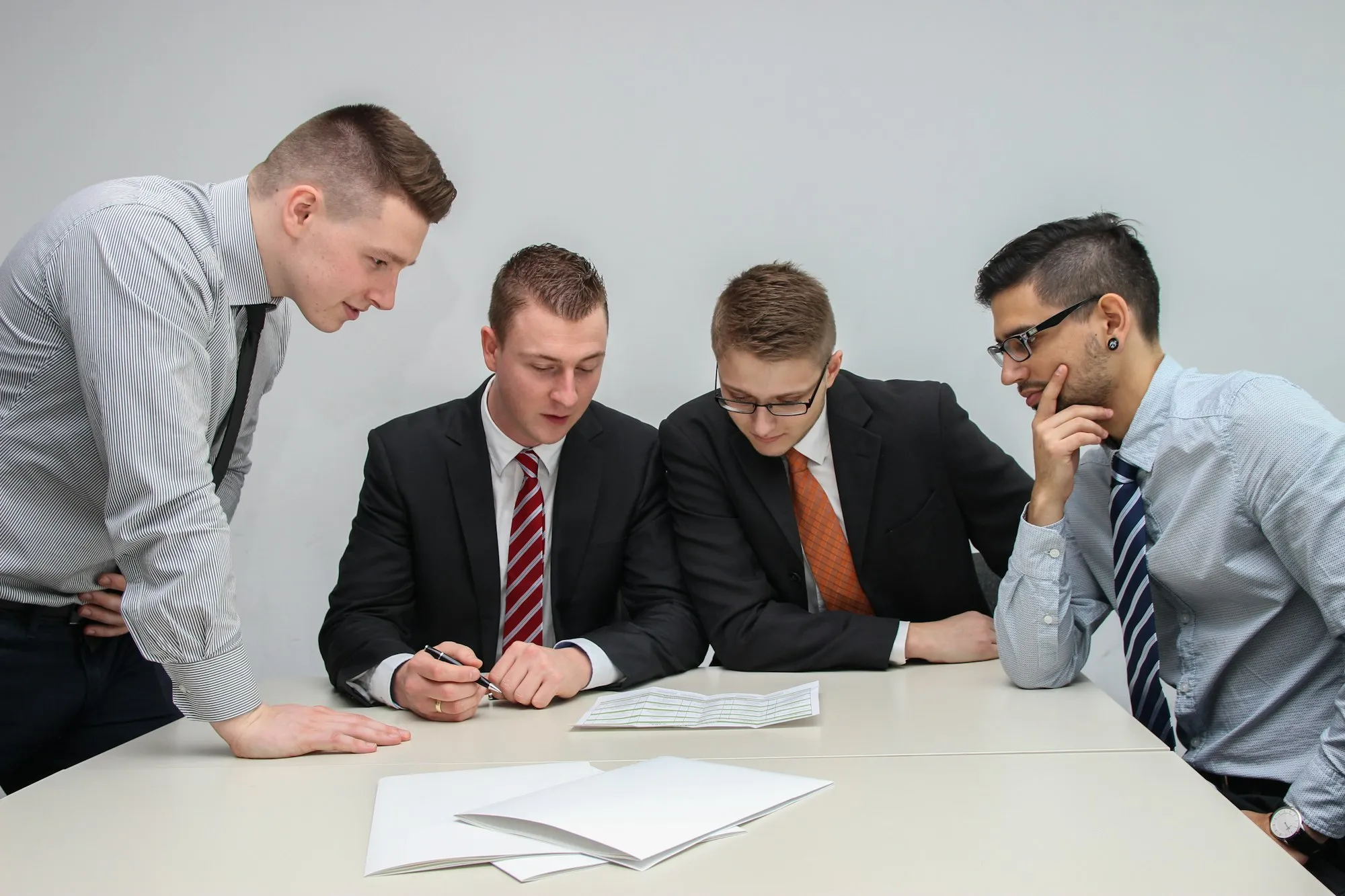 Colleagues around a table examining a printed statement